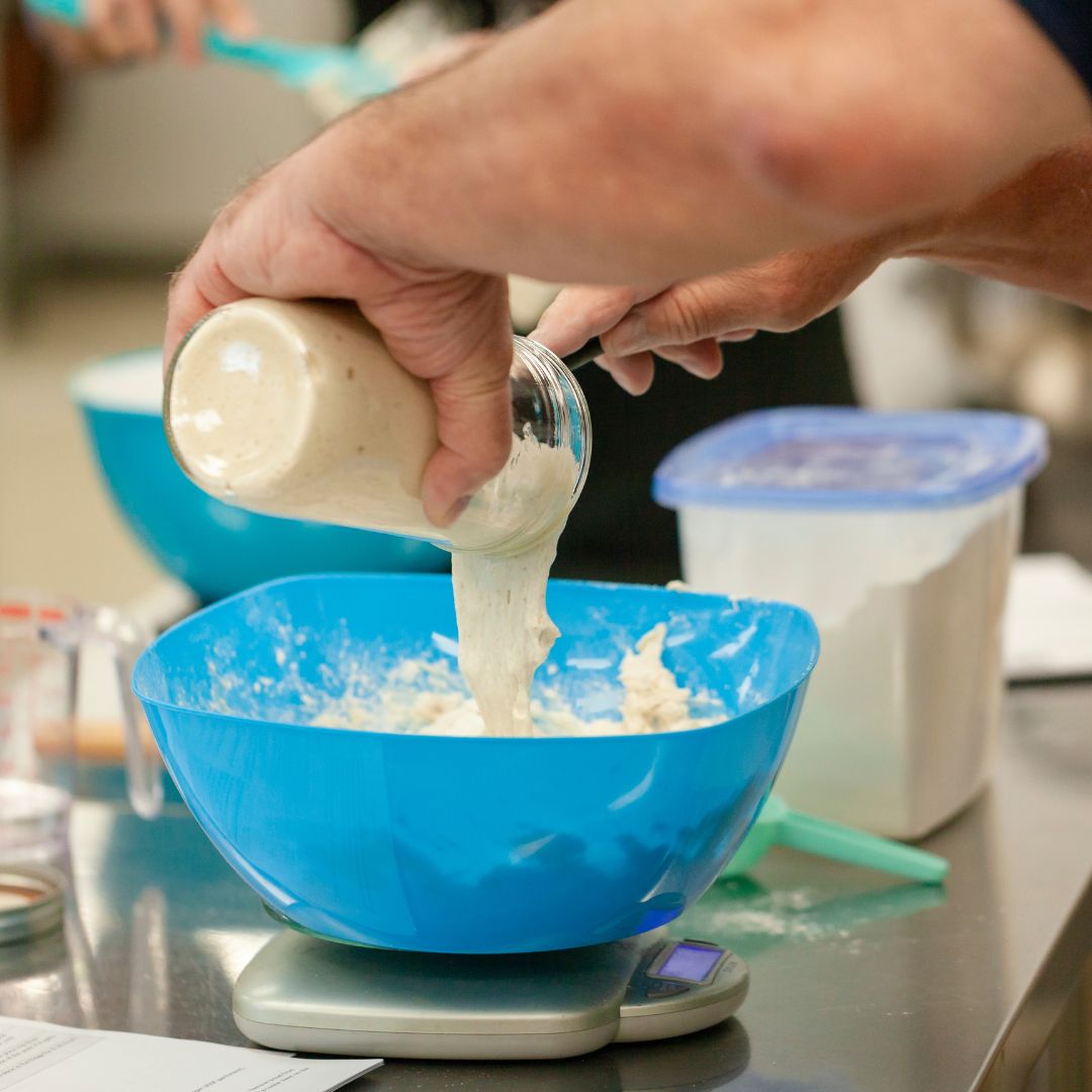 adding sourdough starter levain into flour