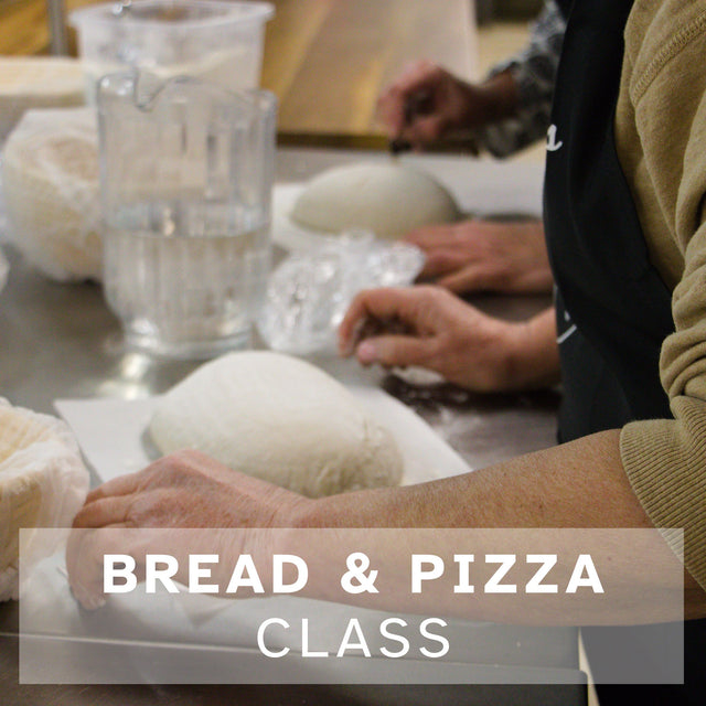 Two peope scoring and readying sourdough for the oven