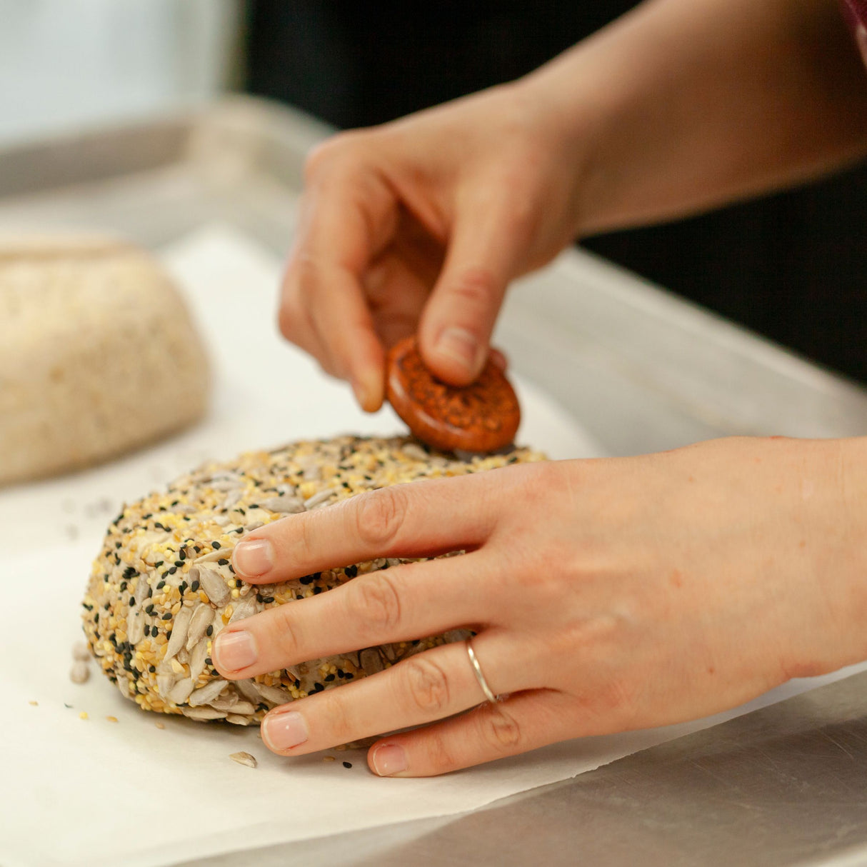 hands scoring sourdough with bread lame