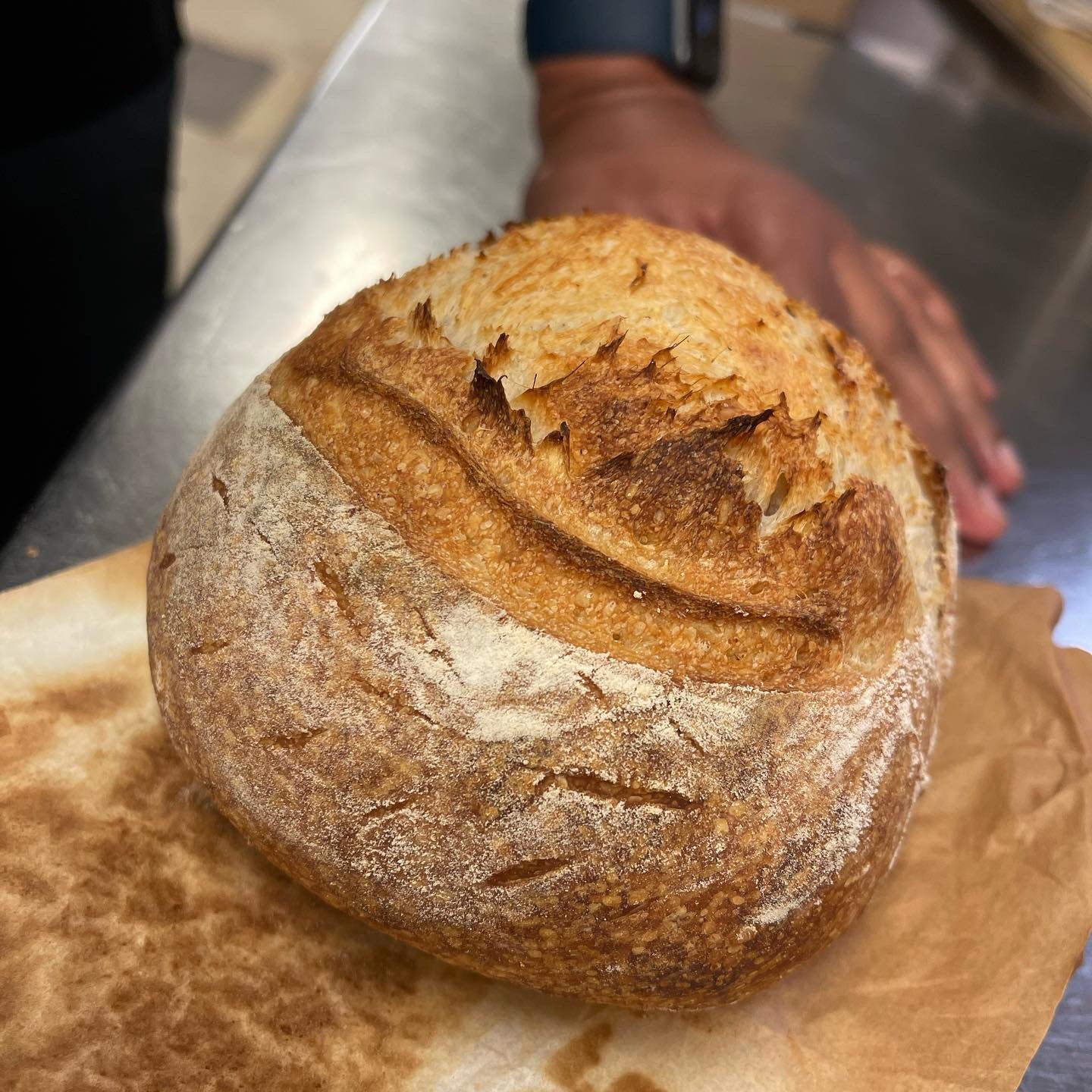 loaf of sourdough baked bread on parchment paper