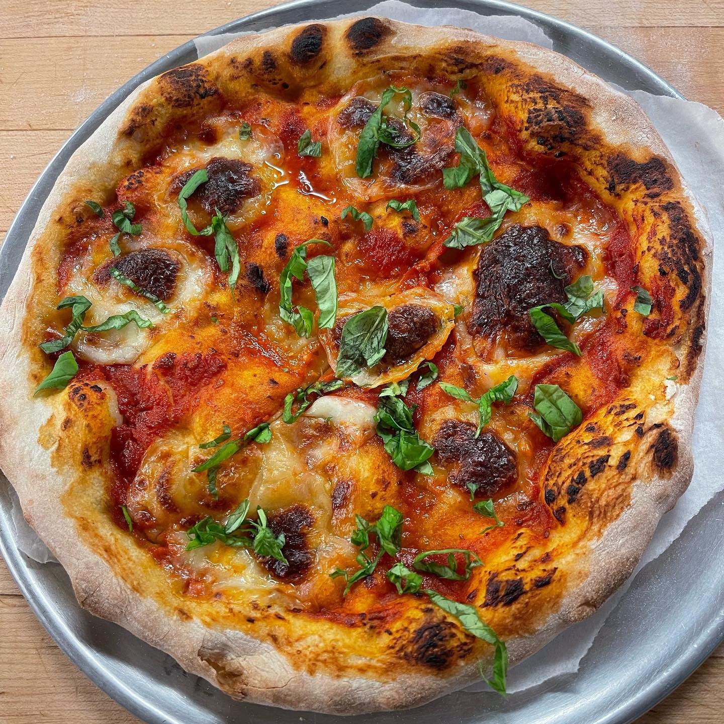 Baked sourdough pizza with fresh mozzarella and basil