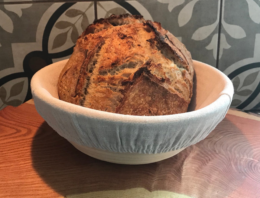 Close-up of baked sourdough dough bread in 9 inch round rattan banneton