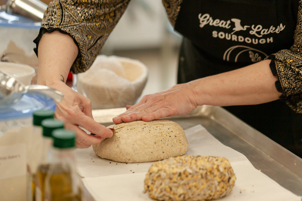 Person scoring sourdough bread in a solo baking class with Great Lakes Sourdough.