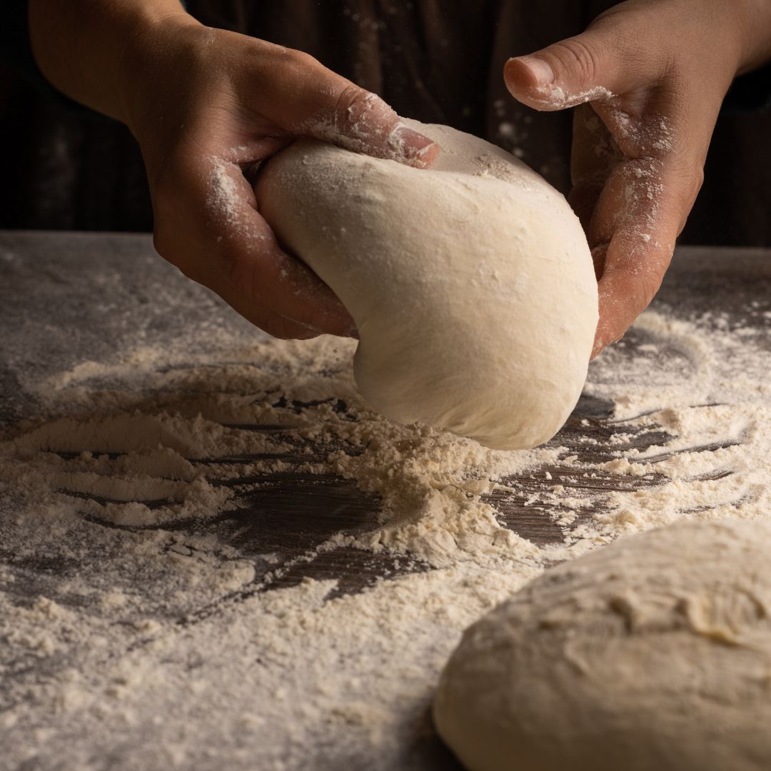 dough in hands on floured surface