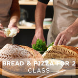 two loaves of sourdough bread with two people preparing he toppings