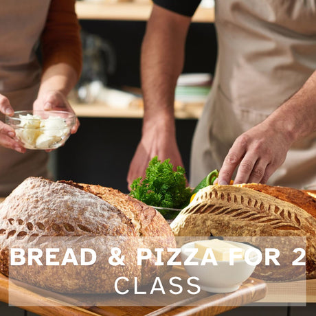 two loaves of sourdough bread with two people preparing he toppings