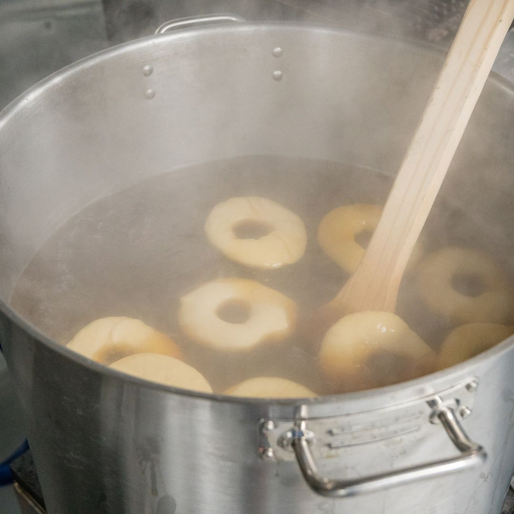 big pot of boiling water with bagels