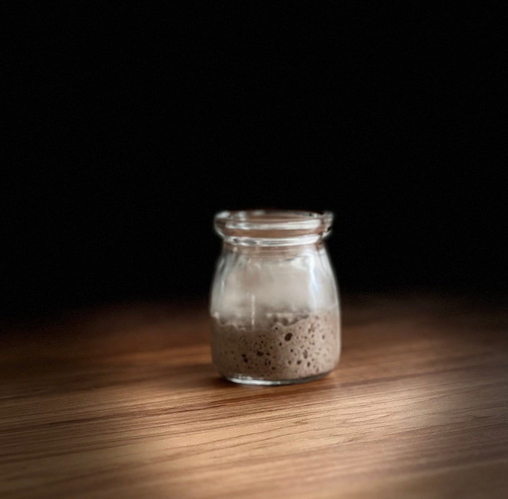 active rye starter with lots of bubbles in a cute jar