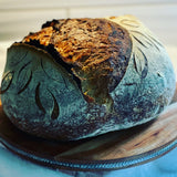 artisan sourdough loaf on round cutting board